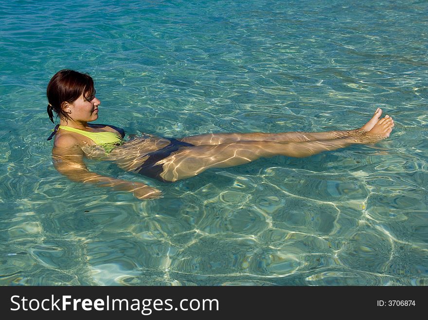 Young woman is relaxing on a blue water level of beautiful Ionian Sea. Young woman is relaxing on a blue water level of beautiful Ionian Sea.