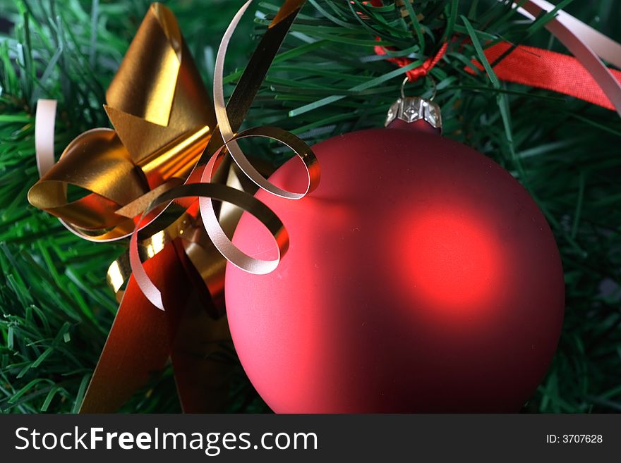 Red ball hanging from christmas tree.