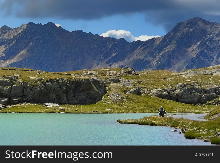 Lake and motorbike driver in the Italian Alps. Lake and motorbike driver in the Italian Alps