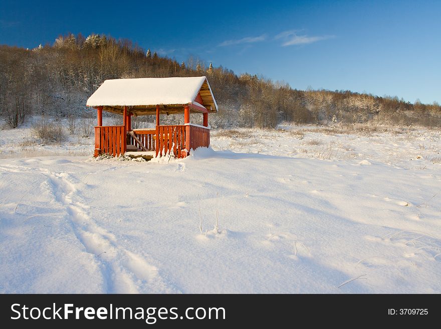 Small pergola in a snow at a high hill