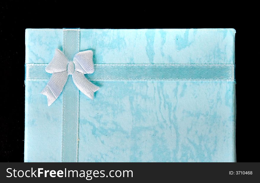 Blue gift box with ribbon on black isolated