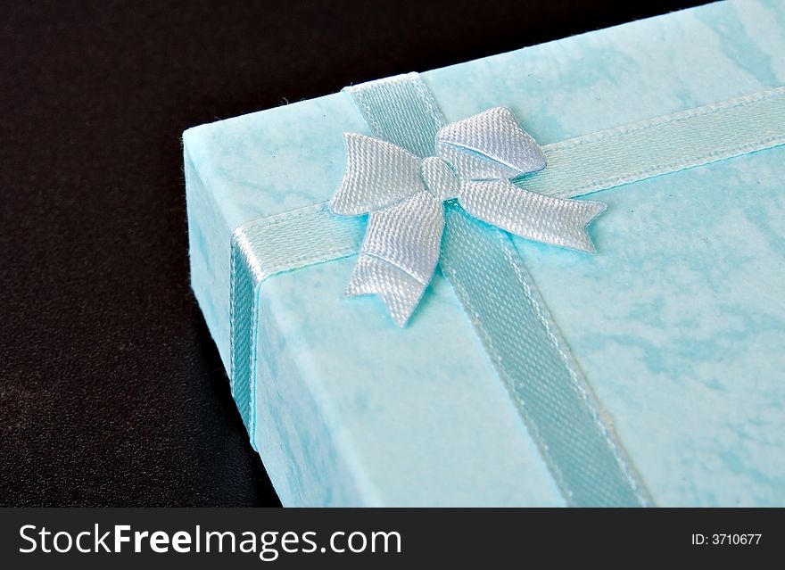 Blue gift box with ribbon on black ISOLATED. Blue gift box with ribbon on black ISOLATED