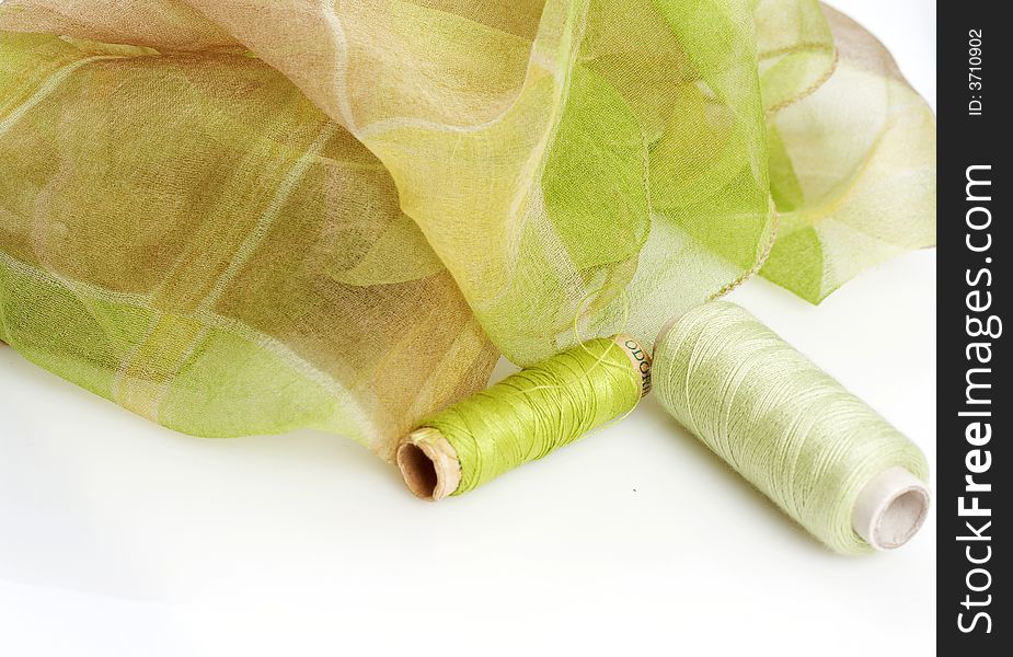 Greenish silk scarf and matching threads, delicate pattern. Greenish silk scarf and matching threads, delicate pattern