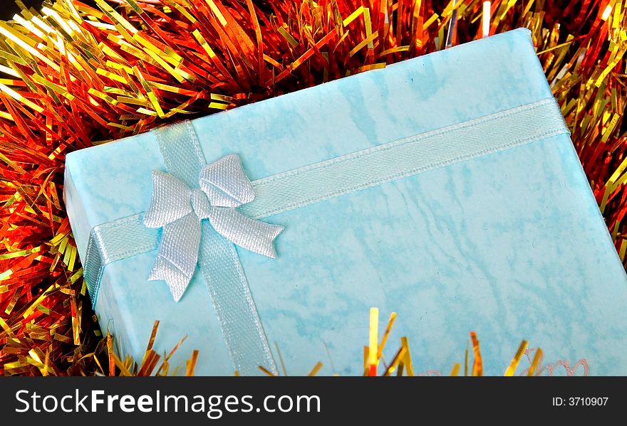 Blue Christmas gift with ribbon on colorful  decorations. Blue Christmas gift with ribbon on colorful  decorations
