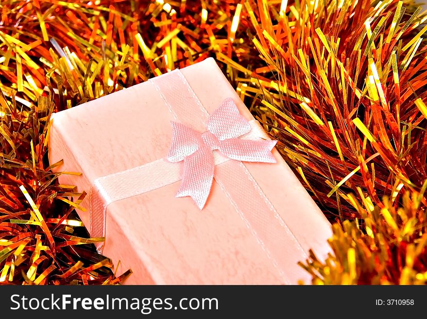 Pink Christmas gift with ribbon on colorful decorations. Pink Christmas gift with ribbon on colorful decorations