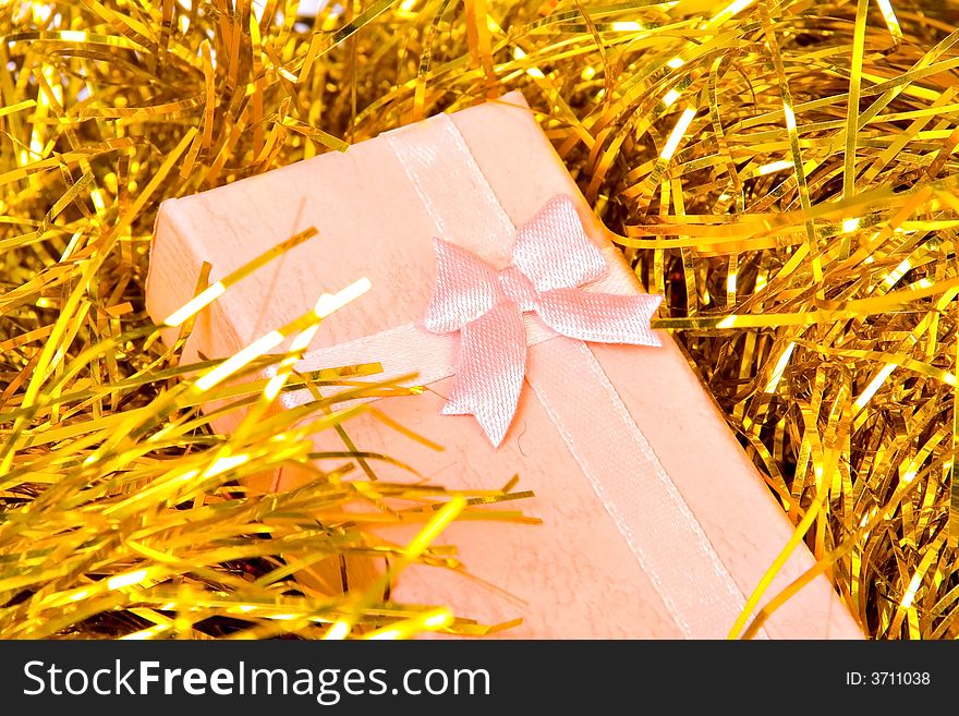 Pink Christmas gift with ribbon on gold  decorations. Pink Christmas gift with ribbon on gold  decorations