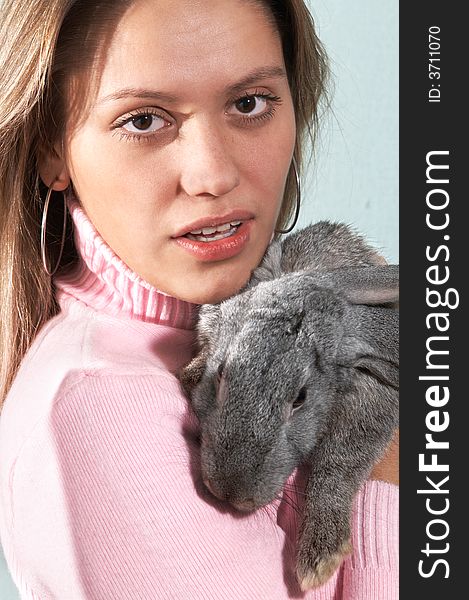 Portrait of attractive girl with rabbiton grey