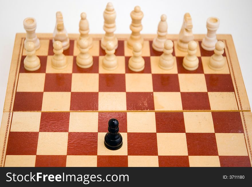 A carved marble chess board and wooden chess pieces. Focus to foreground.