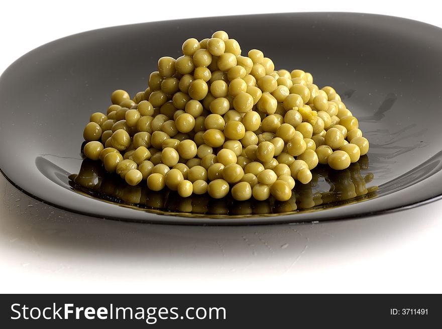 Fresh raw green peas in black plate