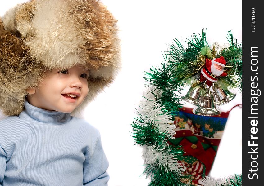 Little child in hat near christmas tree. Little child in hat near christmas tree