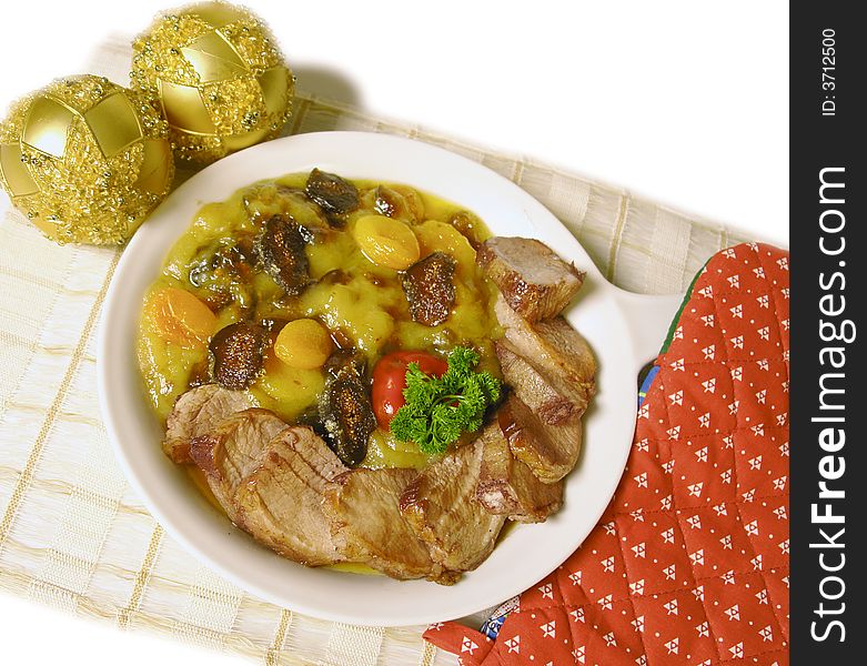Pork served with a sauce of dried fruit and christmas decoration. Pork served with a sauce of dried fruit and christmas decoration