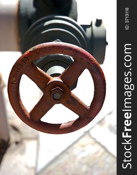 A rusty red valve wheel on an isolated background. A rusty red valve wheel on an isolated background