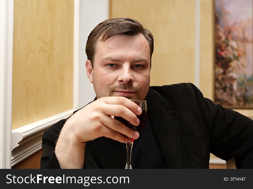 The man with glass posing at restaurant