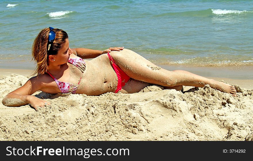 Teenager posing in the sand near the sea