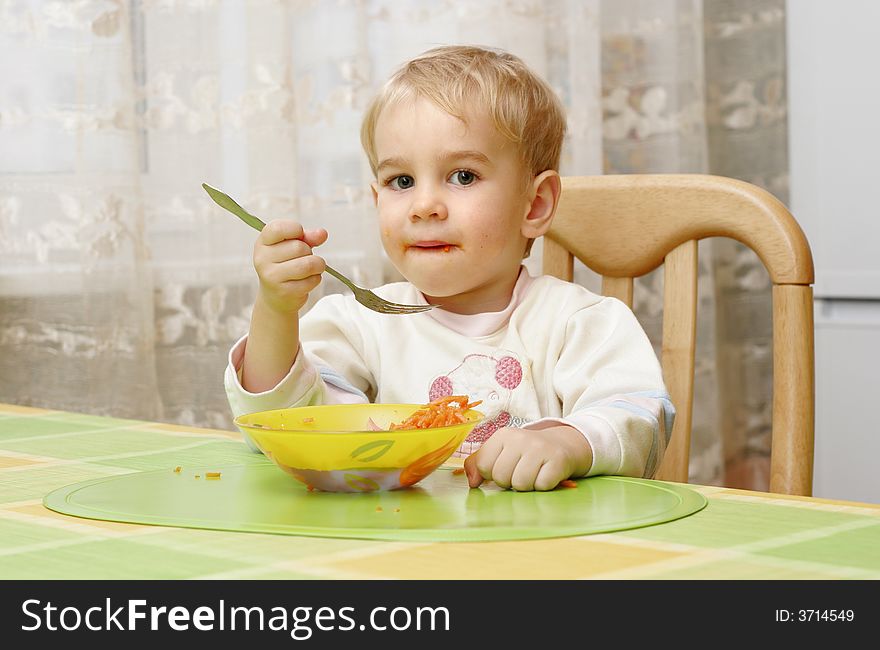 A little boy eating a healthy carrot salad