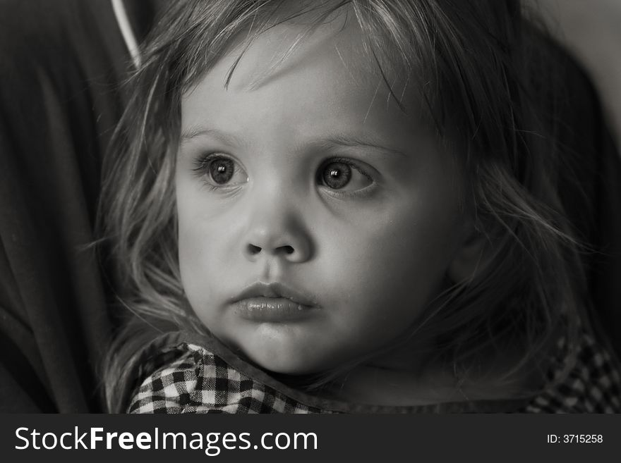 Black-and-white portrait of the girl at mother on hands