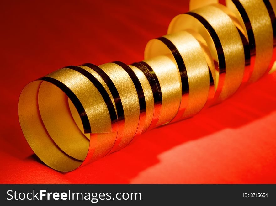 Golden curly ribbon on red background. Golden curly ribbon on red background
