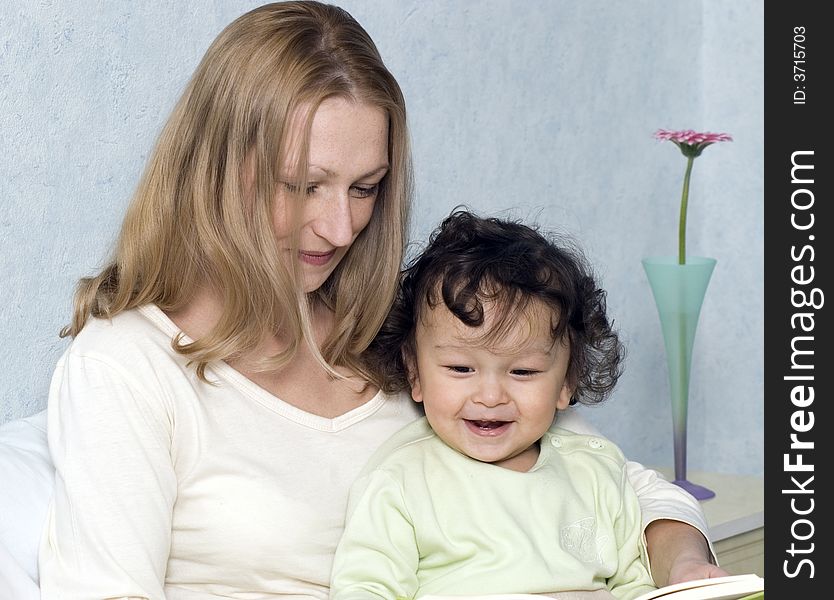 Mother reads to the child the book. Mother reads to the child the book.