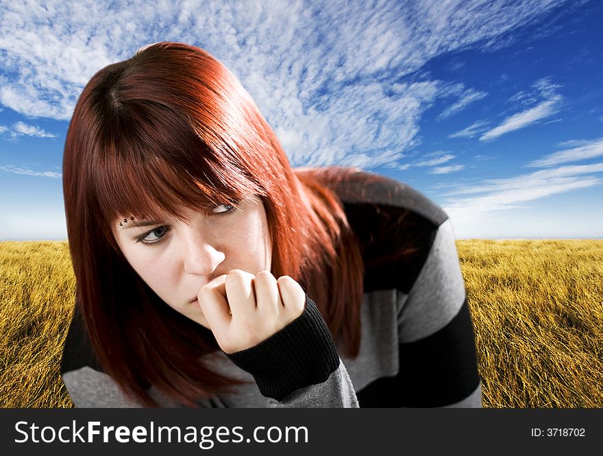 Pensive redhead girl biting nail