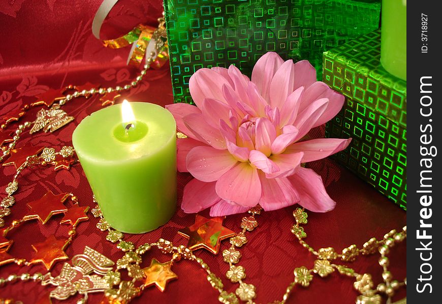 Celebration table (candles, flowers and gift on red background)