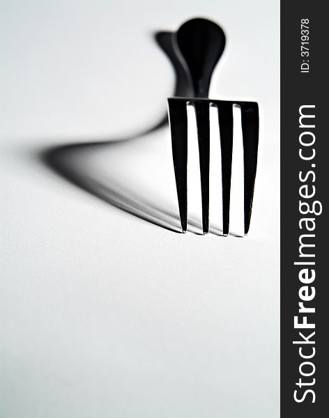 High contrast close-up of a fork with defined shadows. High contrast close-up of a fork with defined shadows