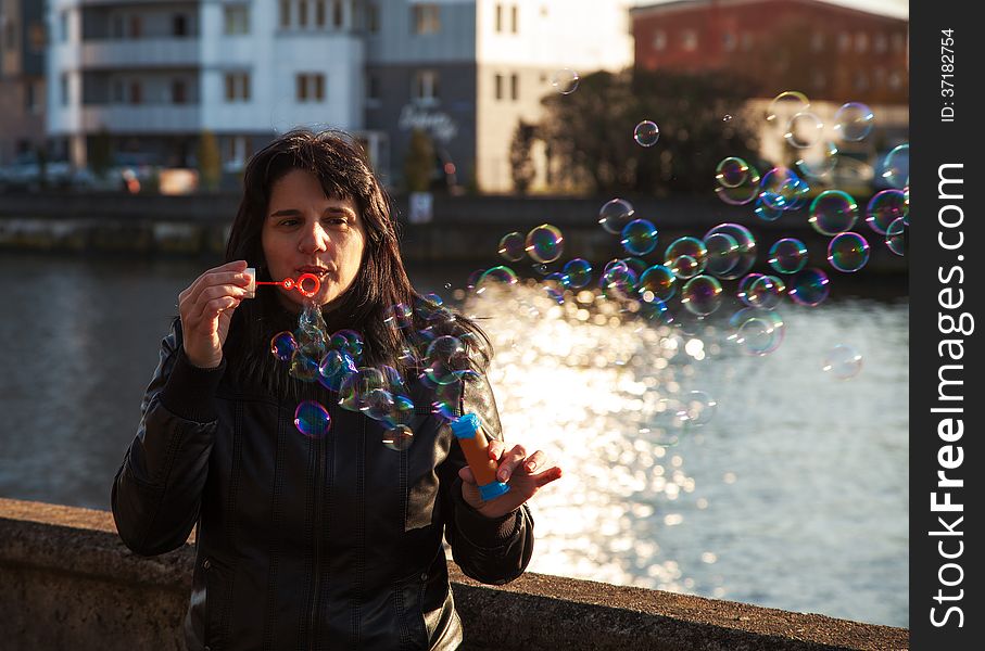 Young beautiful woman blows bubbles outdoor