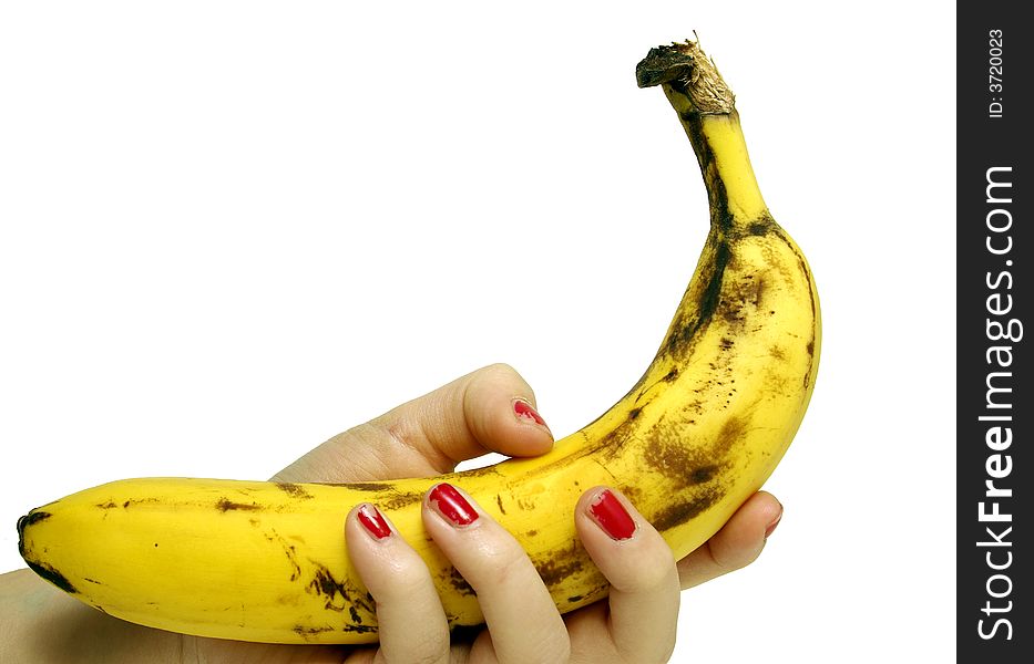 A slightly rotting ripe banana in female hand, fading red nail-polish isolated on white