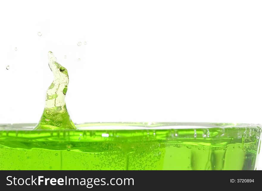 A big green lemonade blob dropping into a glass. A big green lemonade blob dropping into a glass