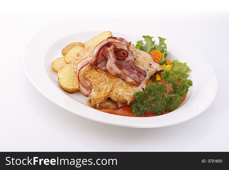 Pork meat with bacon and deep fried potatoes over a white background. Pork meat with bacon and deep fried potatoes over a white background