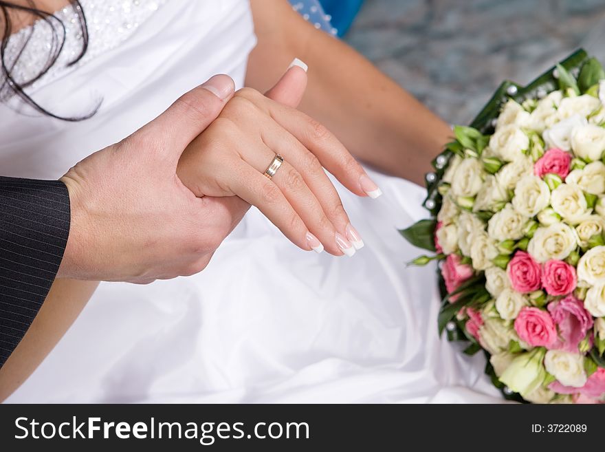 Hands with gold rings, dress and flower bouquet. Hands with gold rings, dress and flower bouquet