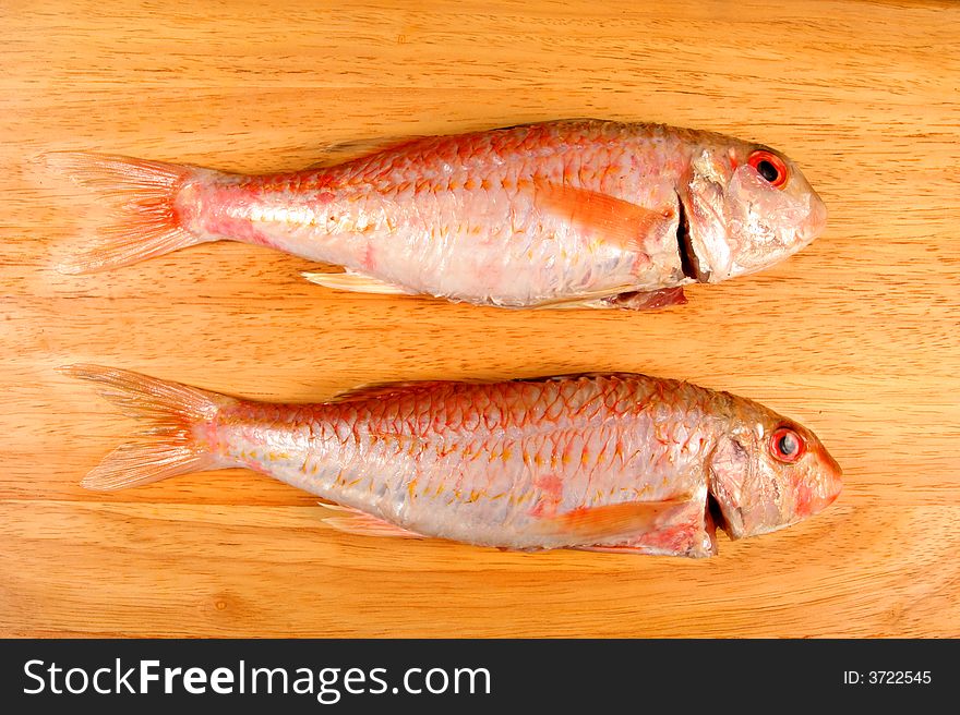 A pair of Red Mullet fish on a wooden board