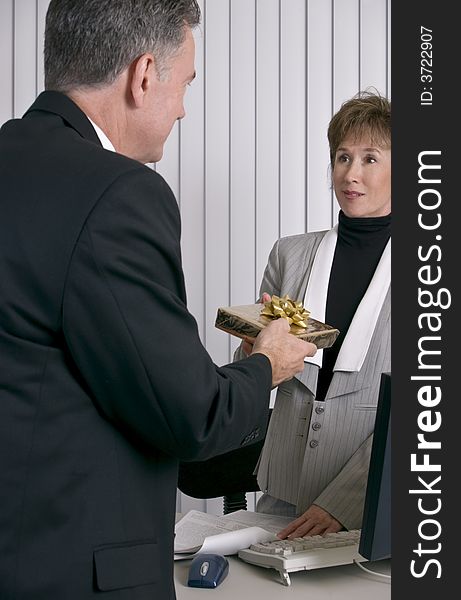A man handing an employee or co-worker a gift. A man handing an employee or co-worker a gift.