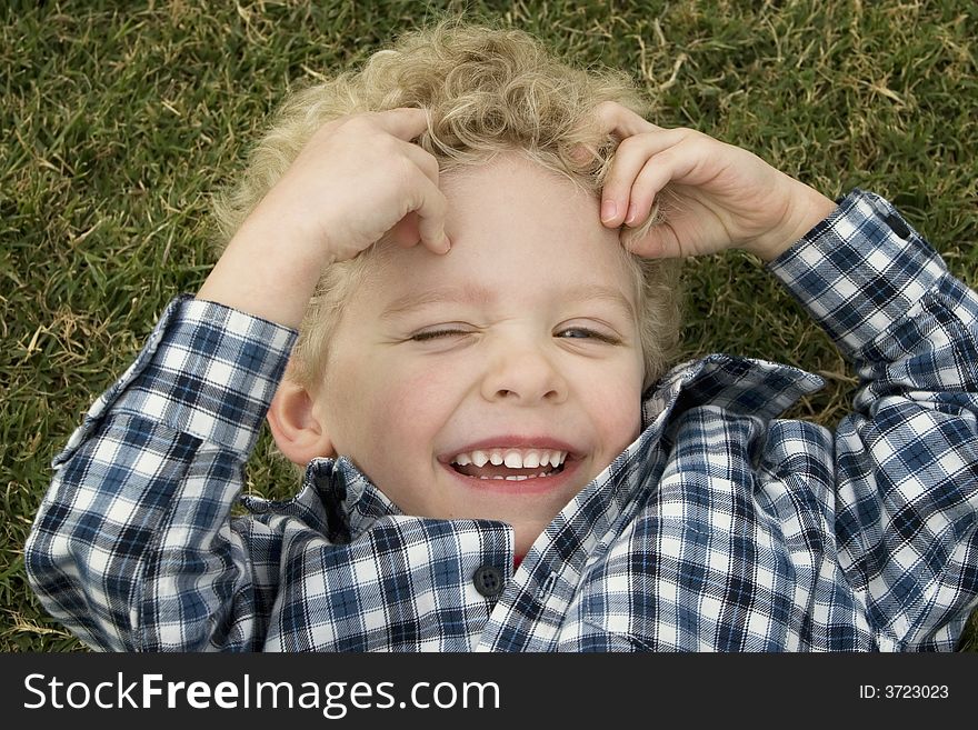 Close Up of a Little Boy Laughing in the Grass. Close Up of a Little Boy Laughing in the Grass