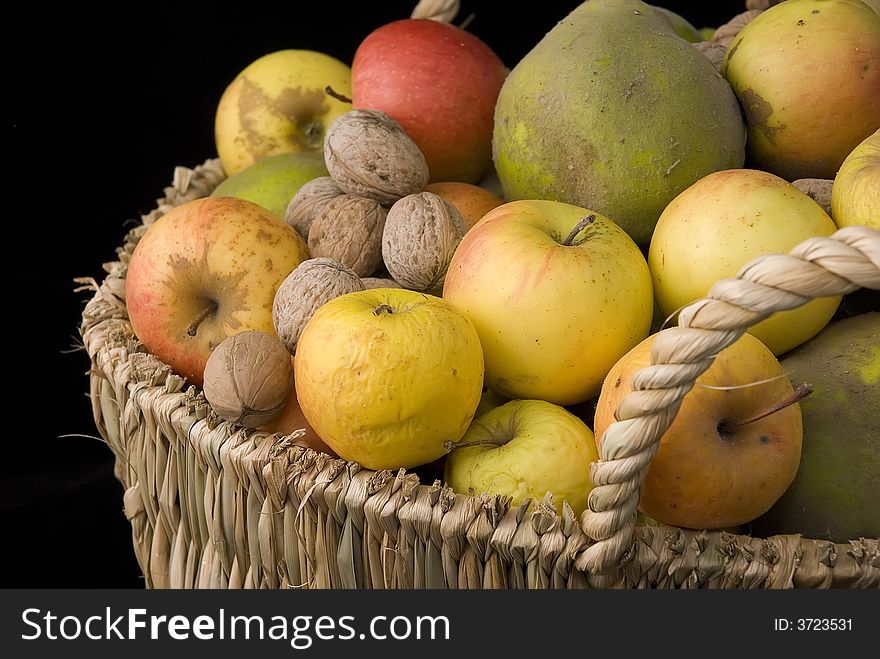 A basket with apples, nuts, quinces. A basket with apples, nuts, quinces