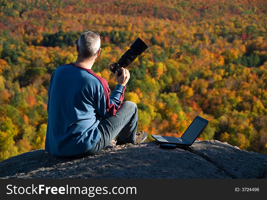 Male photographer shooting at the top of a mountain. Male photographer shooting at the top of a mountain