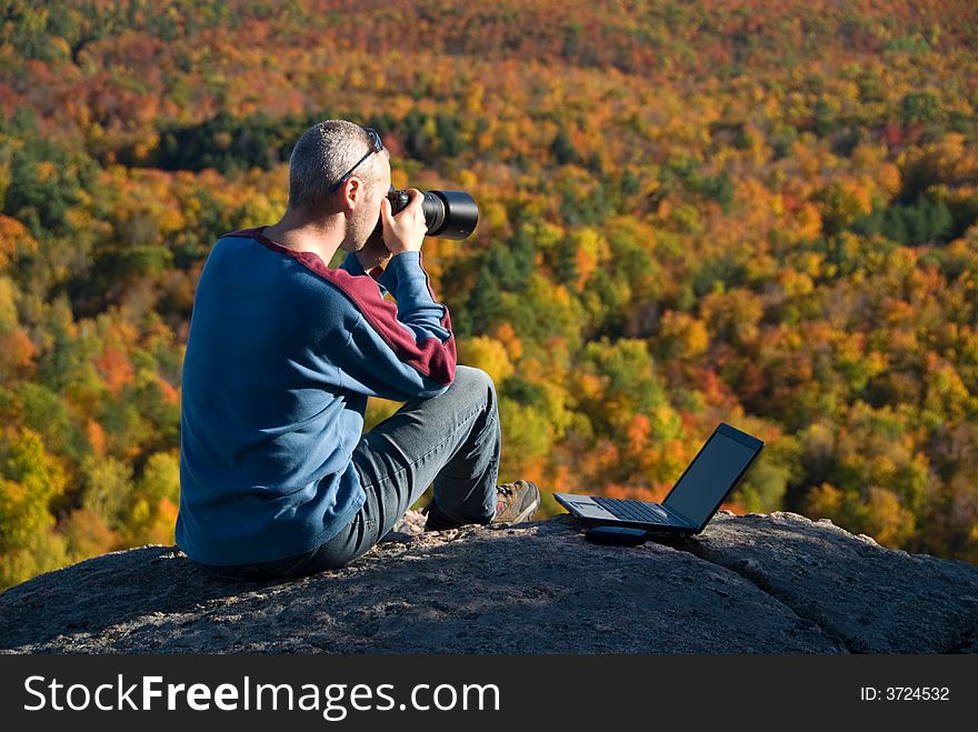 Male photographer shooting at the top of a mountain. Male photographer shooting at the top of a mountain