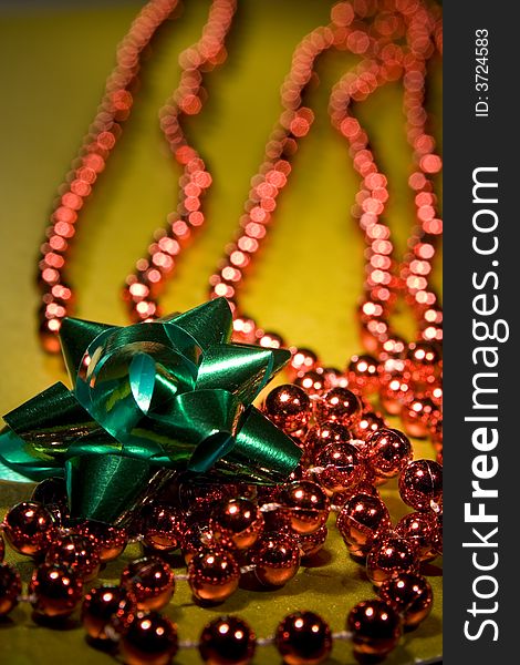 Red christmas beads for tree decoration shot on a gold background