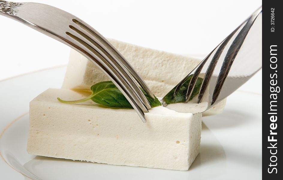 Dessert in a plate with a plug and a knife isolated on a white background. Dessert in a plate with a plug and a knife isolated on a white background