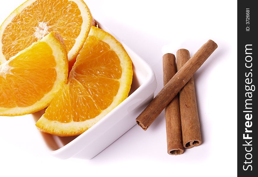 Juicy oranges and cinnamon on the white background