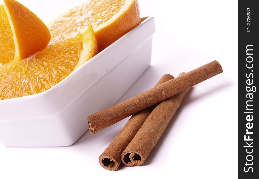 Oranges and cinnamon on the white background