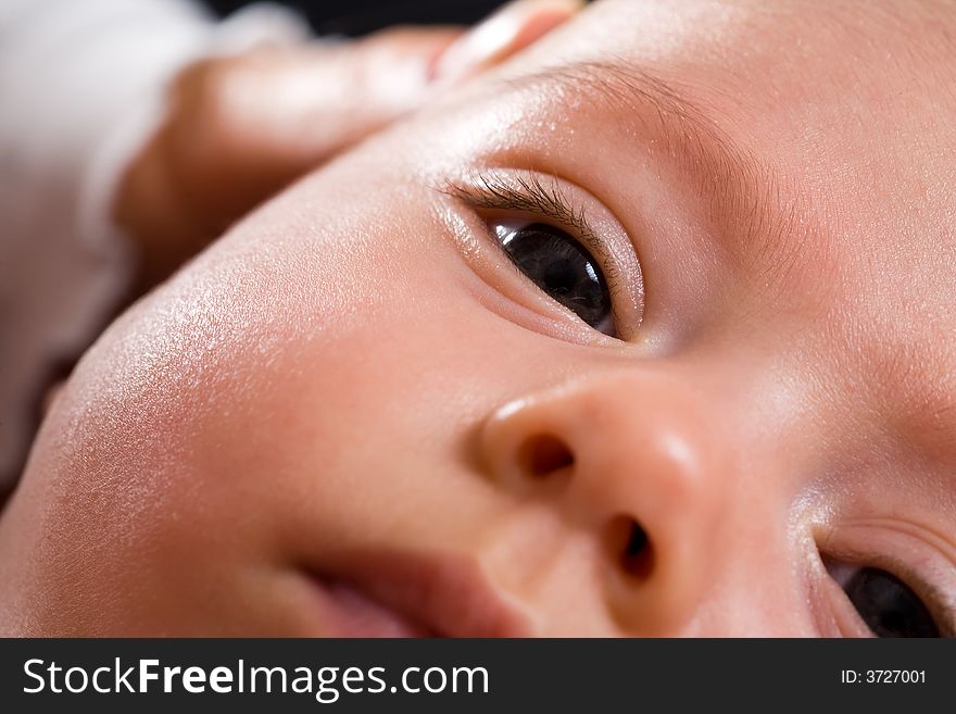 Closeup of a baby's face. Dark eyes. Closeup of a baby's face. Dark eyes.