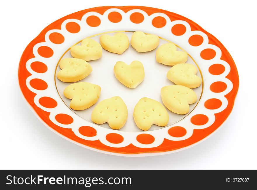 Thin captain in form heart, on a dish with a red pattern. Object on a white background. Thin captain in form heart, on a dish with a red pattern. Object on a white background.