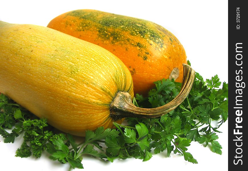 Yellow summer squashes and greens on white background