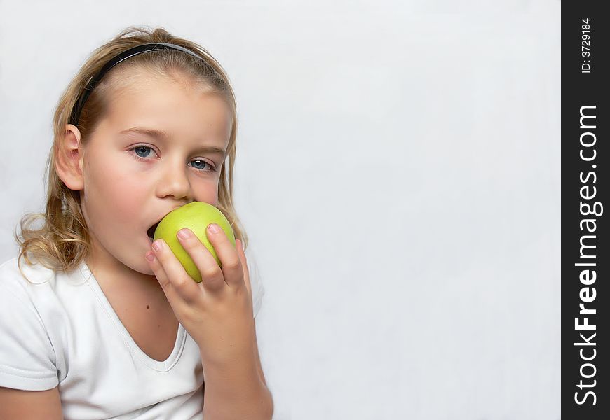 An adorable boy is holding a green apple. An adorable boy is holding a green apple.