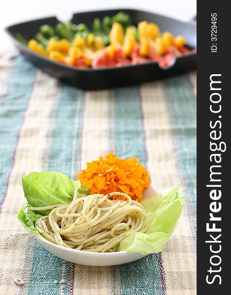 Pasta olio with lettuce and edible flower and colorful rows of capsicums. Pasta olio with lettuce and edible flower and colorful rows of capsicums