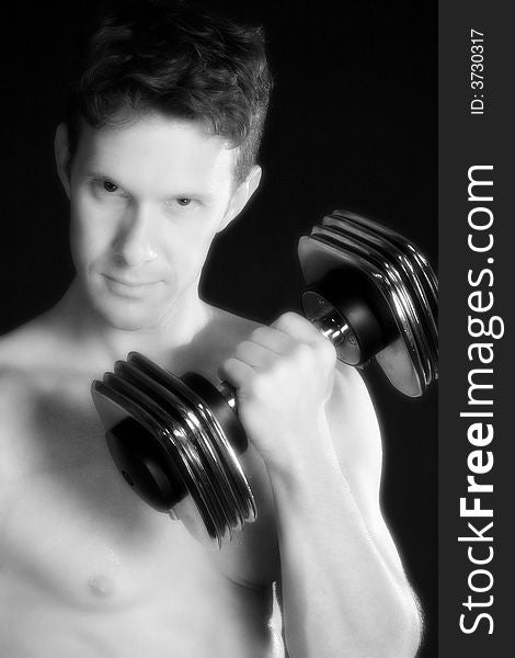 Atractive 30 something man lifting weights over black. Atractive 30 something man lifting weights over black.