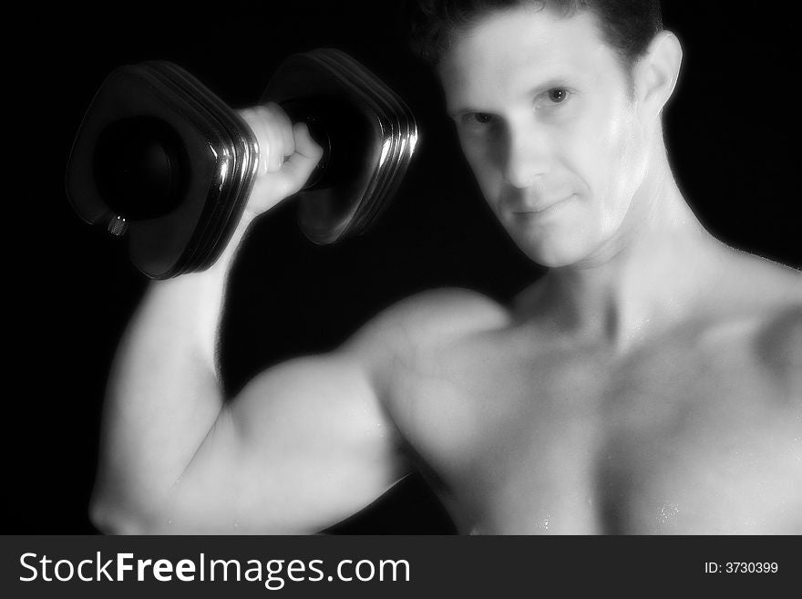 Attractive thirty something man with dumbbell over black. Attractive thirty something man with dumbbell over black.
