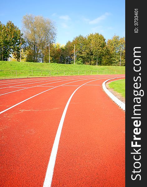 Racetrack, red tarmac, for runners. trees in the background. Racetrack, red tarmac, for runners. trees in the background