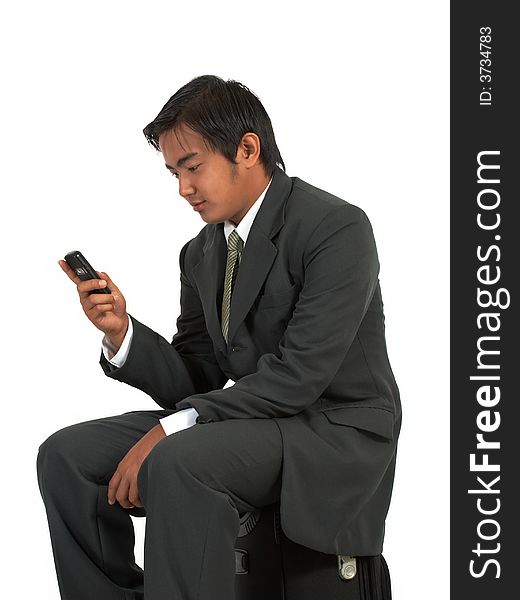 A man sitting on his luggage over a white background. A man sitting on his luggage over a white background