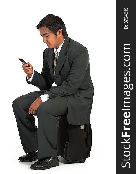 A man sitting on his luggage over a white background. A man sitting on his luggage over a white background